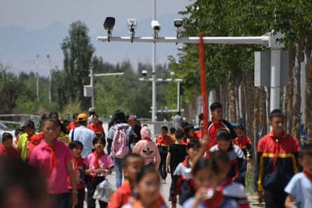 Escolares caminando bajo las cámaras de vigilancia en Akto, en la región china de Xinjiang.