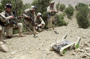 Soldados estadounidenses junto a un robot detector de minas terrestres en Afganistán.