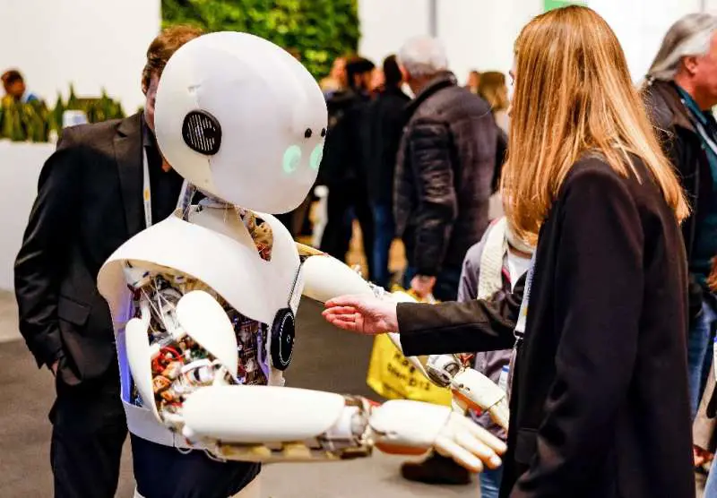 Una mujer interactúa con un robot en una importante feria comercial en Hannover