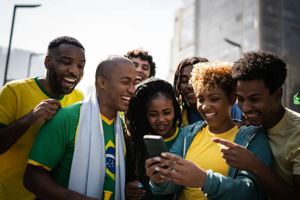 Los fanáticos del fútbol brasileño ven un partido en un teléfono inteligente.