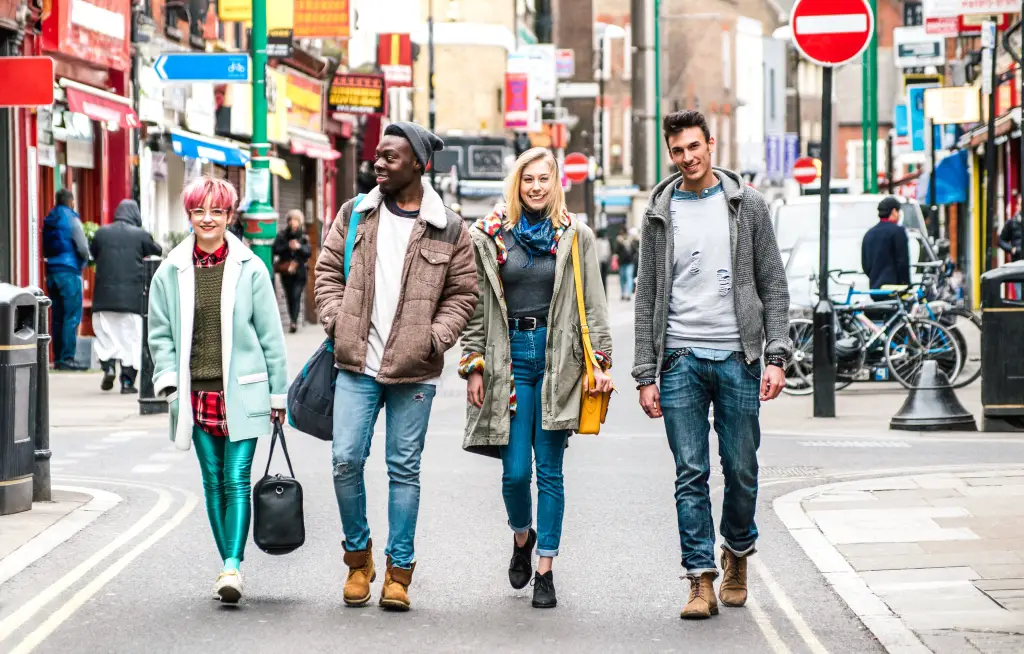 Estudiantes multiculturales caminando por el centro de Brick Lane en Shoreditch, Londres.