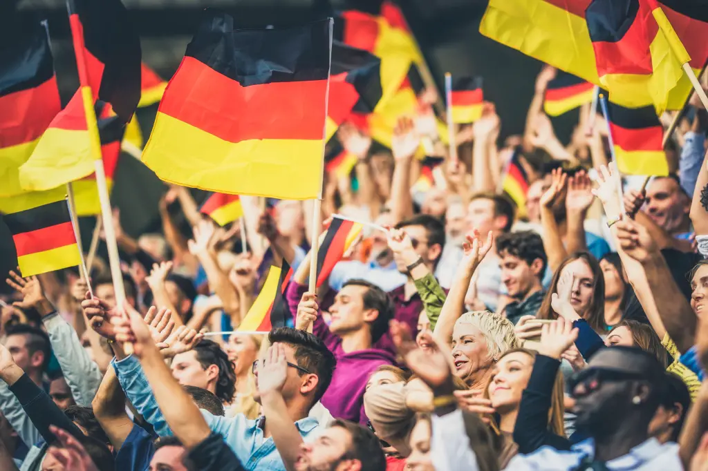 Aficionados al fútbol alemanes ondeando banderas.